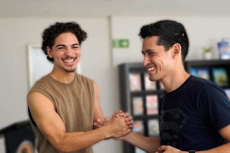 Two people shaking hands and smiling